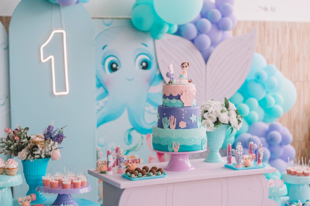 pexels-photo-19976279-19976279 Vibrant mermaid-themed first birthday party decoration with cake, balloons, and sweets.
