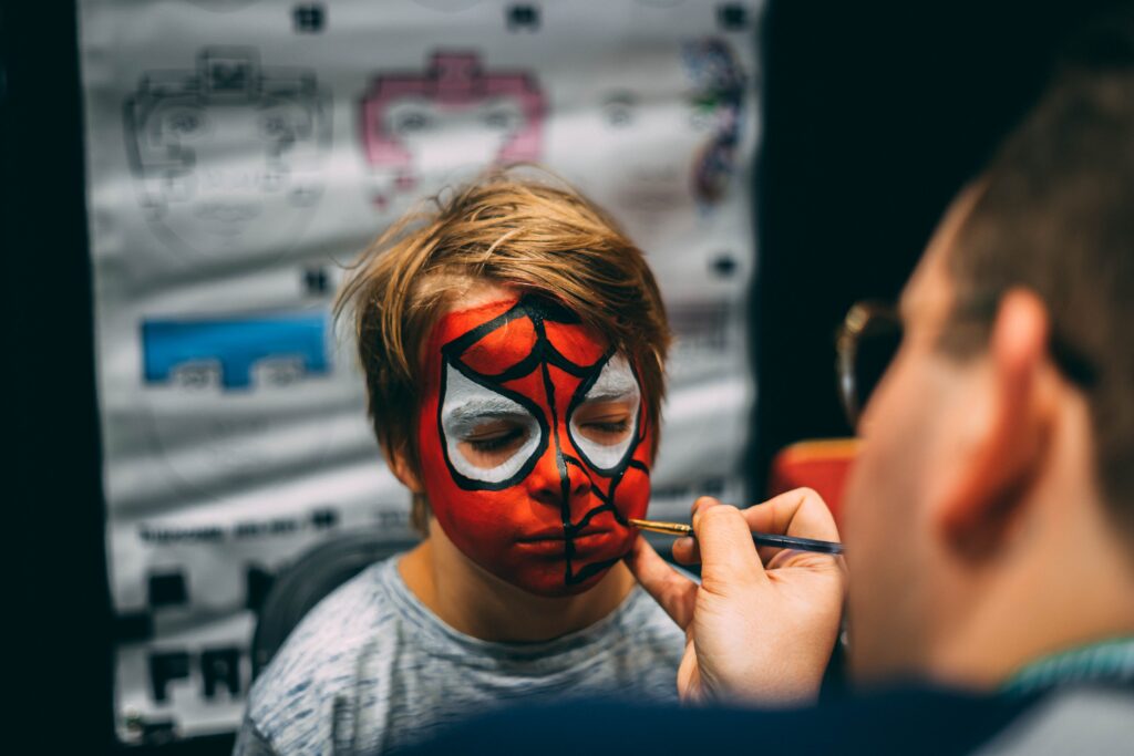 pexels-photo-2353325-2353325 A child enjoys festival face painting with a bold Spider-Man design.