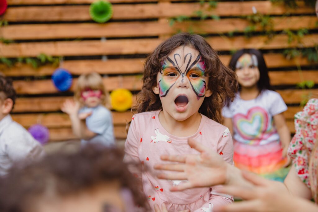 pexels-photo-8385930-8385930 Happy kids enjoying an outdoor party with colorful face paint and playful expressions.